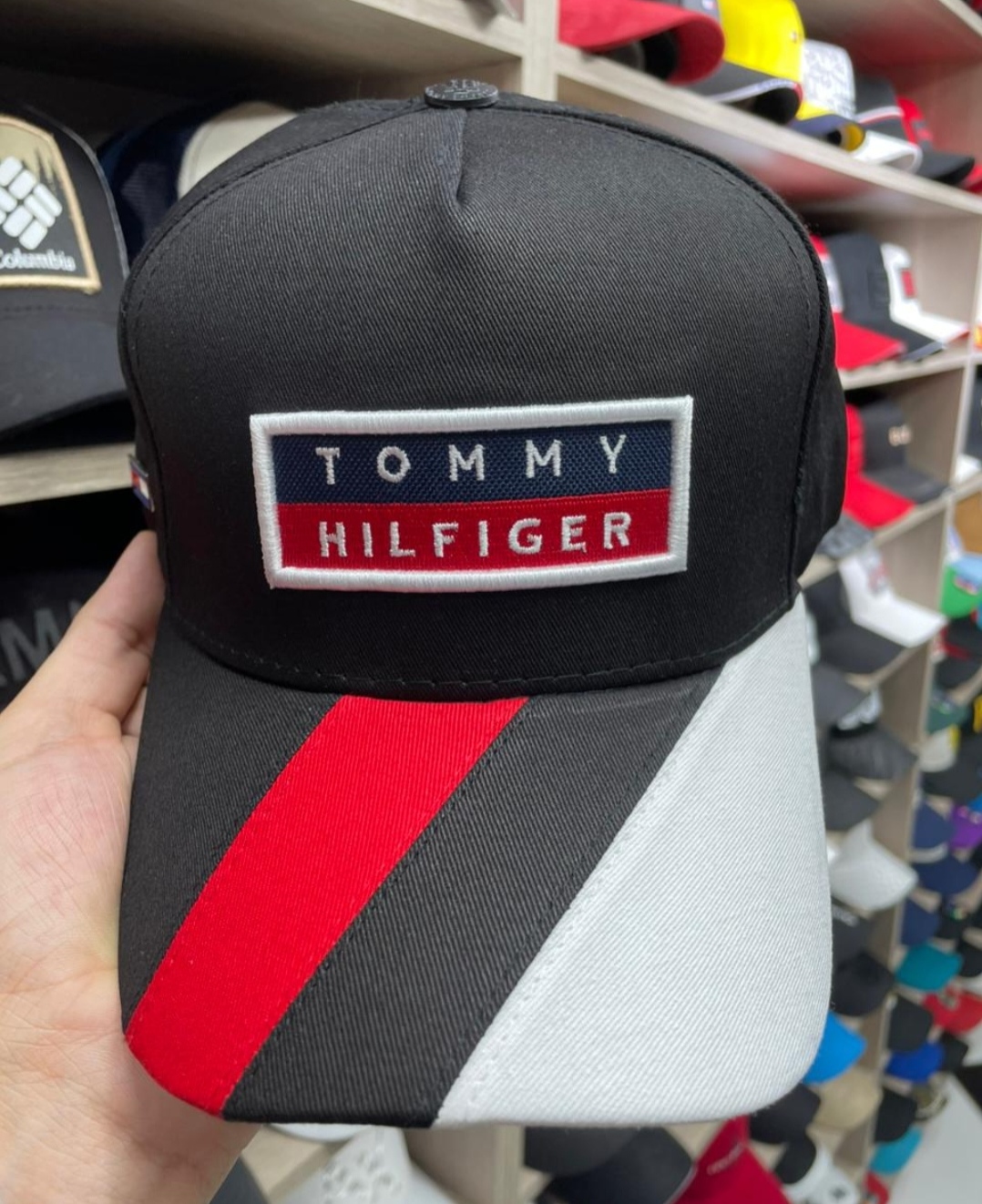 Gorra  Tommy Hilfiger color negro con diseño diagonal en rojo y blanco